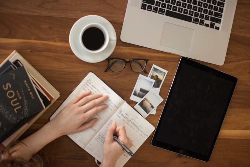 Cozy desk with journal, coffee, and photos