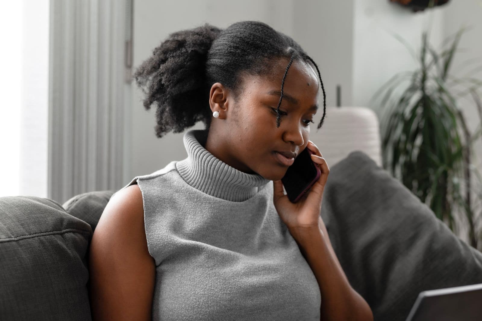 Woman listening to a private phone call at home in soft natural light
